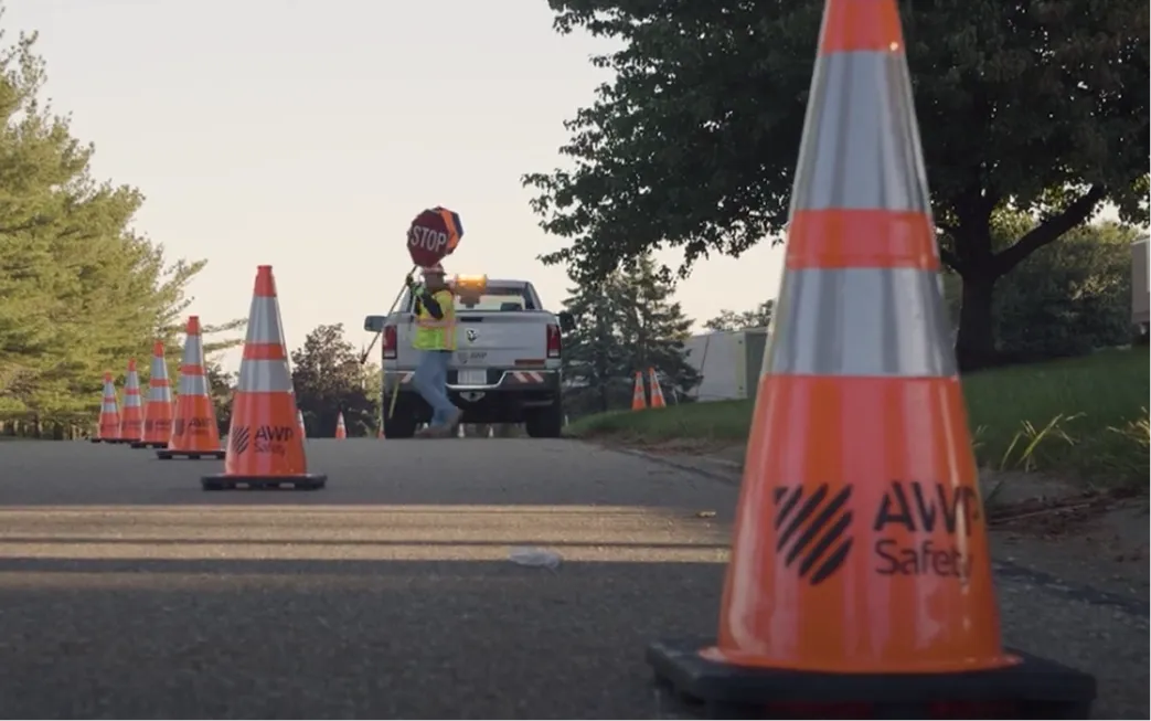 An AWP employee placing cones on a residential street.