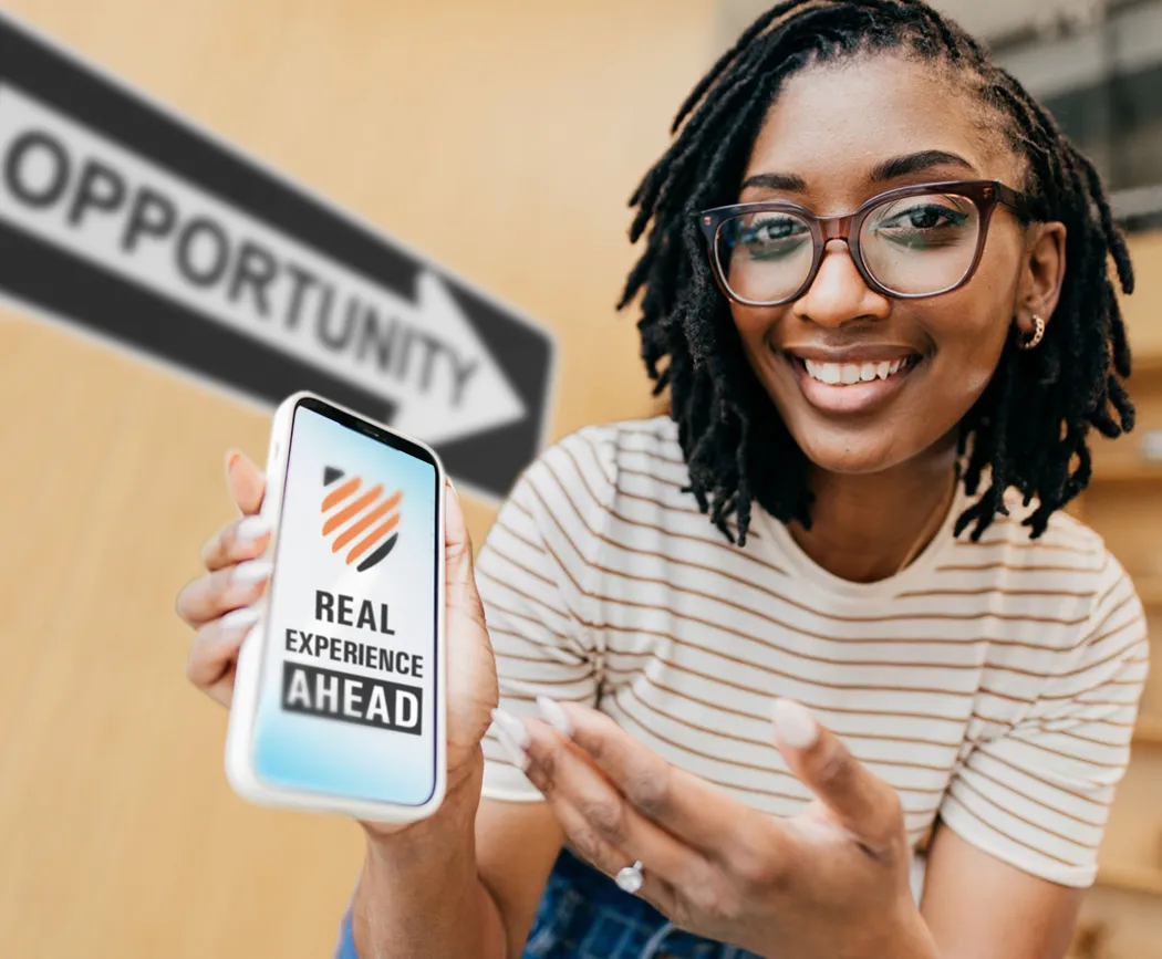 An intern sitting in front of a sign with an arrow that says “Opportunity” and holding a phone with a screen that says “Real Experience Ahead.”