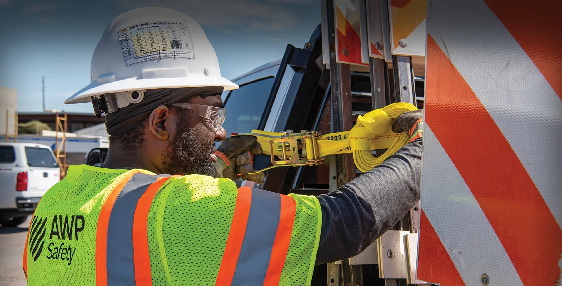 A protector securing a load of signs on the back of a truck.