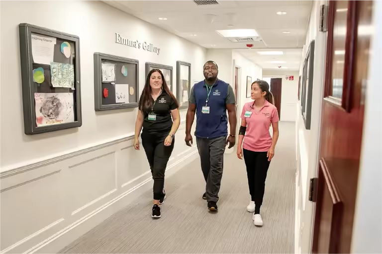 Three Brown University health professionals walking down the hall.