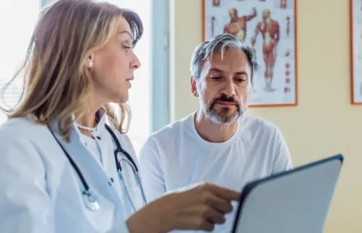  	A doctor and patient in an exam room.