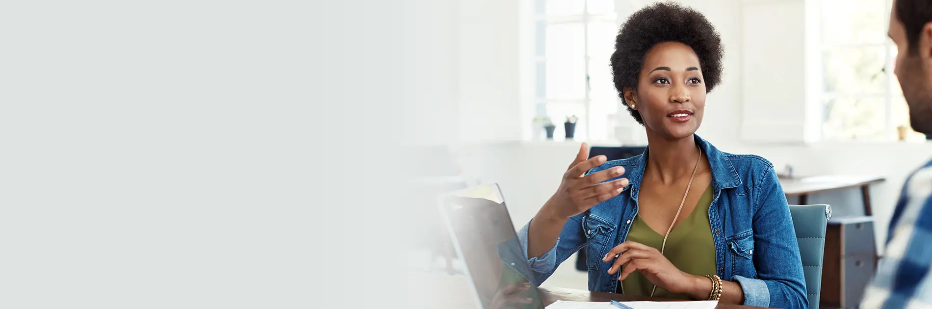 A female staff member speaks to a male colleague in an office setting.