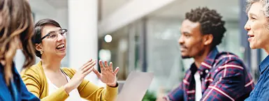 A senior female executive collaborates with three colleagues at a conference table. (Mobile)