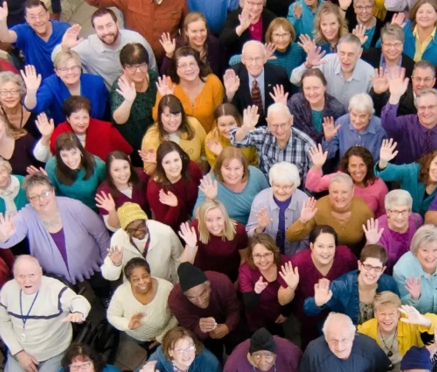 An overhead picture of Cassia community residents and team members waving