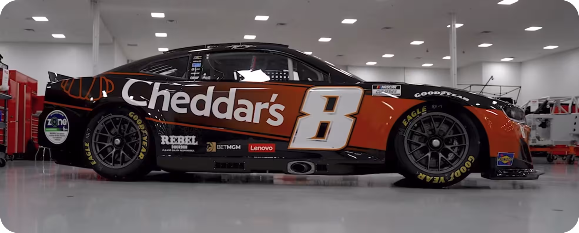 A black race car with a red stripe down the side that has the Cheddar’s logo and the number 8.