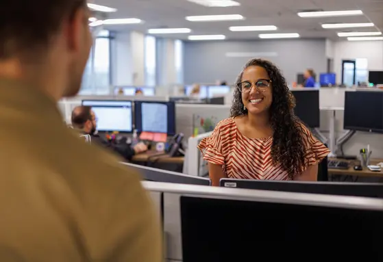 The Christ Hospital Health Network employees smiling and talking over cubical walls.