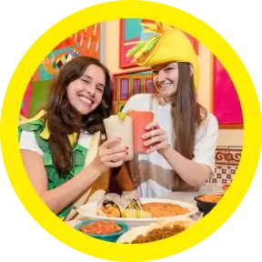 Two Chuy’s customers smiling in a cheers.