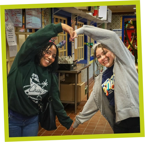 Two Chuy’s team members holding their hands in the shape of a heart.