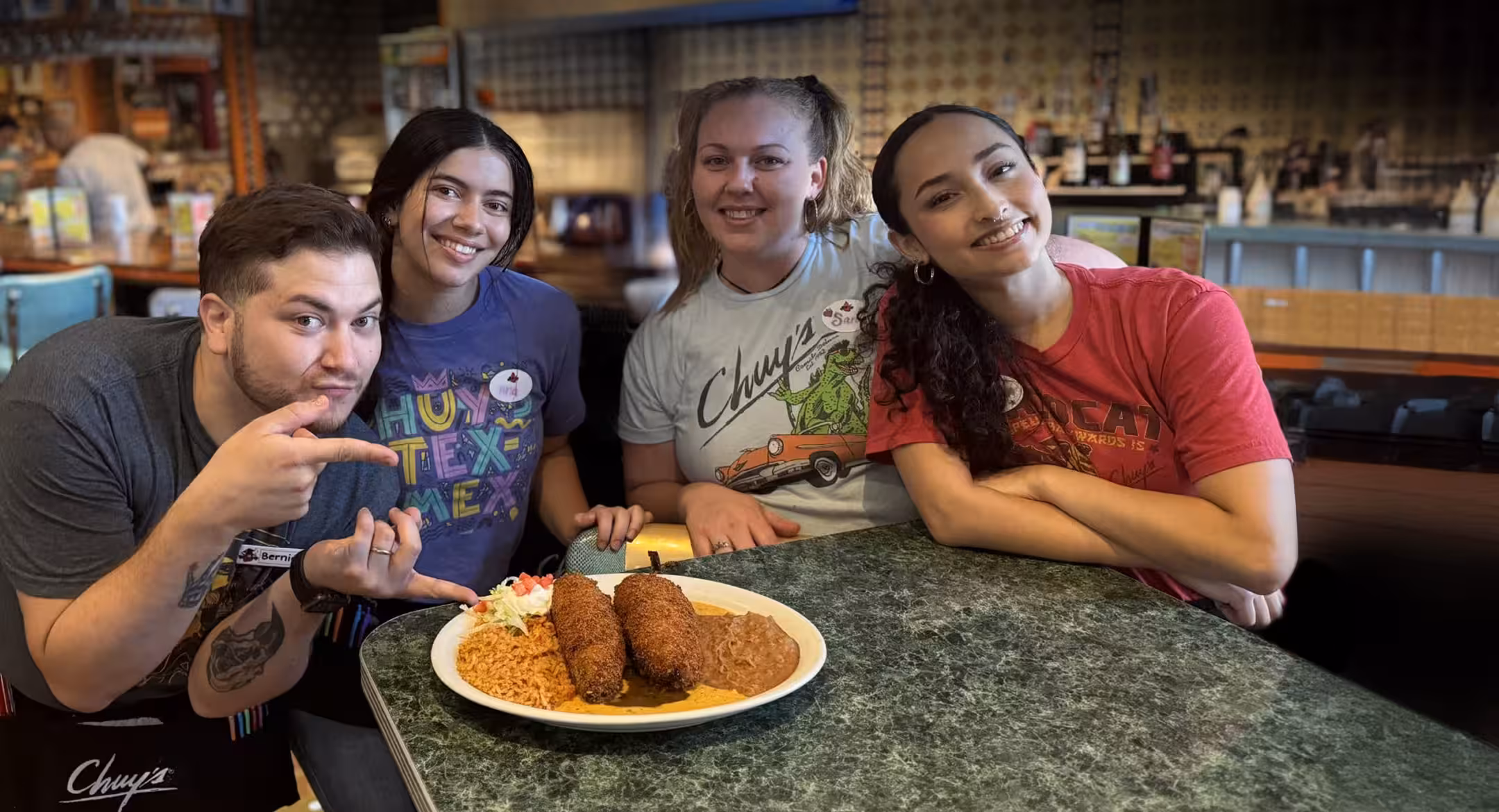 A Chuy’s manager smiling and talking with a team member.