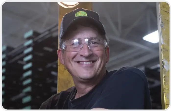 An employee of Cincinnati Incorporated standing in PPE gear in a warehouse.