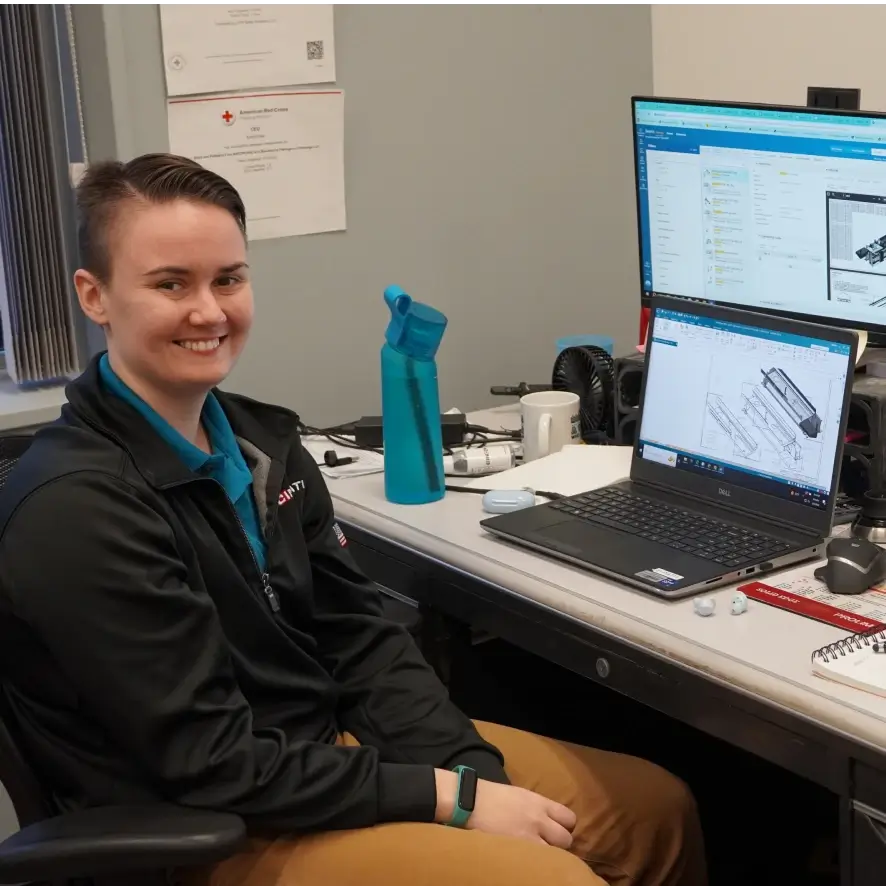 A team member at Cincinnati Incorporated sitting at a desk with a smile.