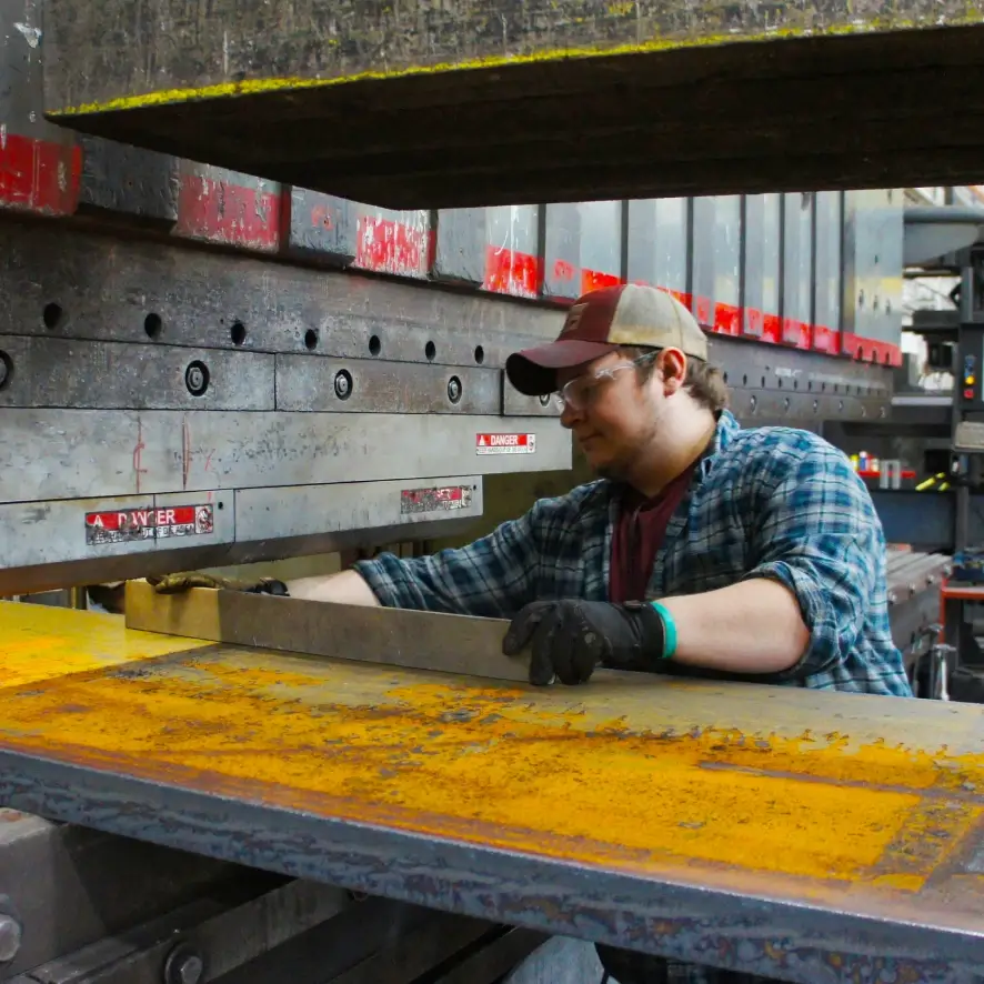 A technical services employee working with machinery at Cincinnati Incorporated.