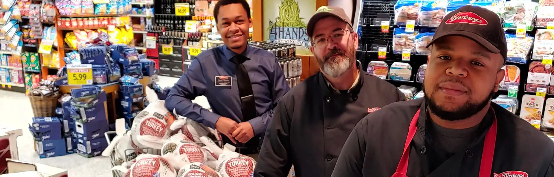A smiling manager checks in with two employees in the meats section of a Dierbergs store.