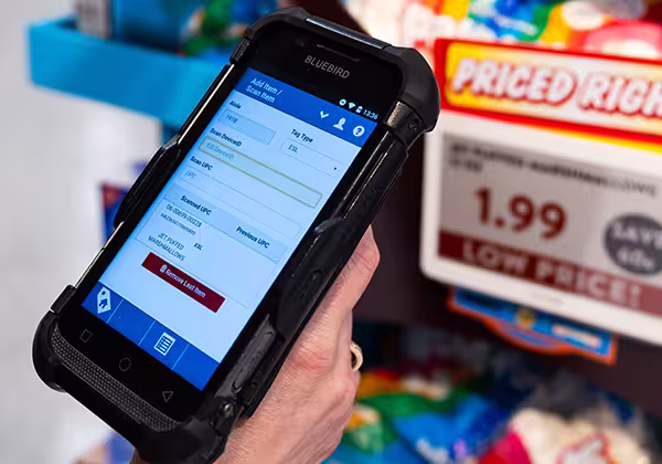 A grocery store scanner being used by an associate