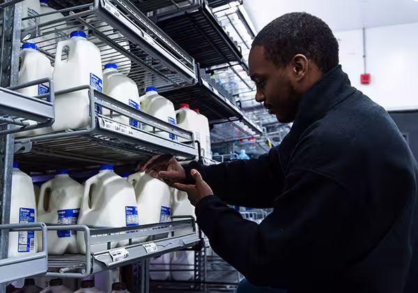 A dairy/frozen manager checking milk stock