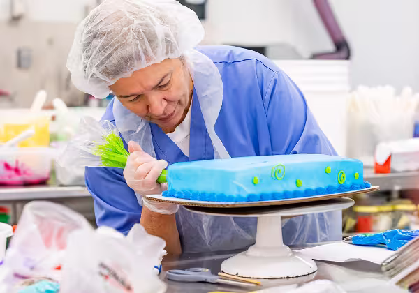 A Dierbergs team member decorating a cake
