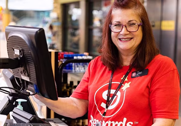 A smiling retail cashier team member