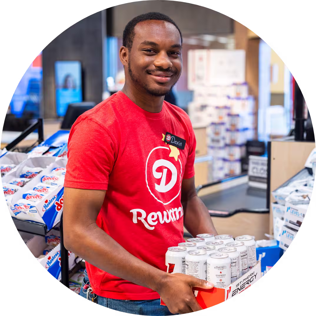 A Dierbergs retail associate holding groceries and smiling.