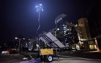 A piece of ECAM security equipment situated in front of a large parking garage.