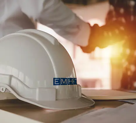 A hard hat with the EMH&T company logo.