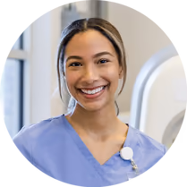 A happy Fairfax employee in blue scrubs.