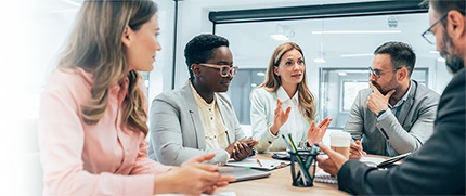 A diverse group of corporate professionals having a discussion in a conference room.