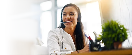A female employee wearing a headset and smiling.
