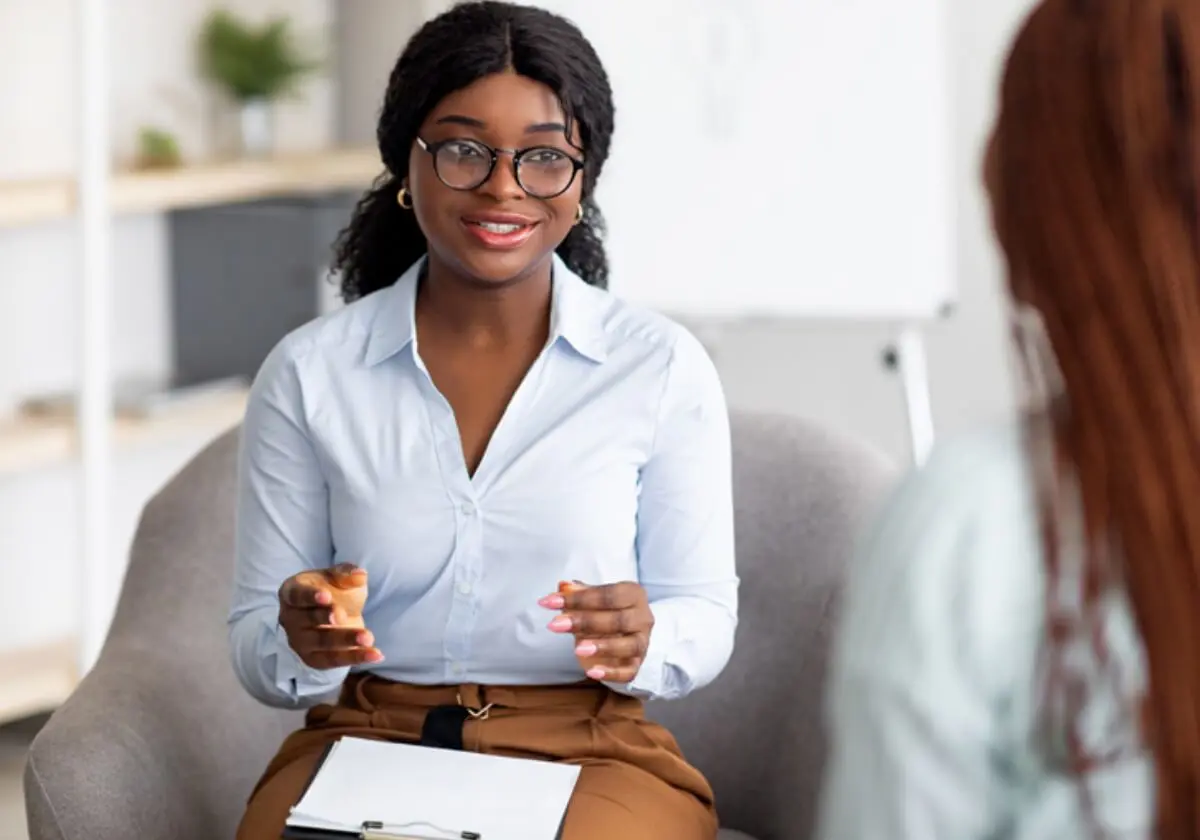 A clinical worker sitting down and speaking to a client.