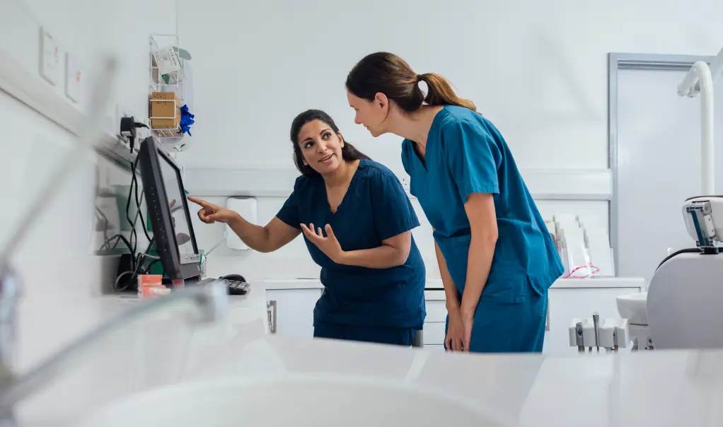 A dentist training a dental assistant.