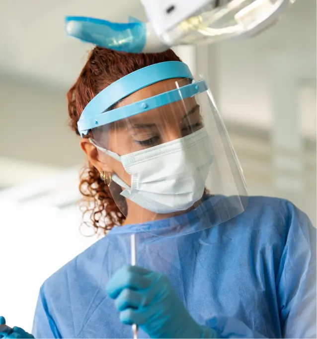 A dentist wearing PPE and performing a procedure on a patient at Gen4 Dental Partners.