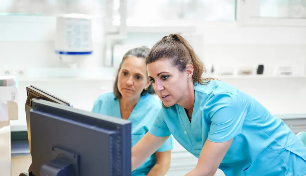 A dental hygienist training a dental assistant.