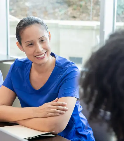 Two receptionists smiling and chatting.