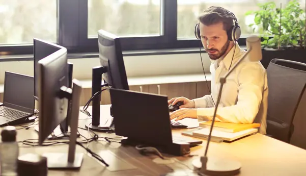 A male IT professional works with his laptop in an office setting.