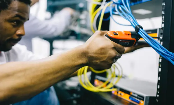 A male technician repairs some equipment.