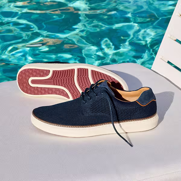 Pair of Shoes sitting on top of a pool bench
