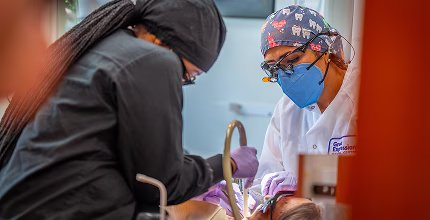 A group of dental professionals smiling together as they take a selfie.