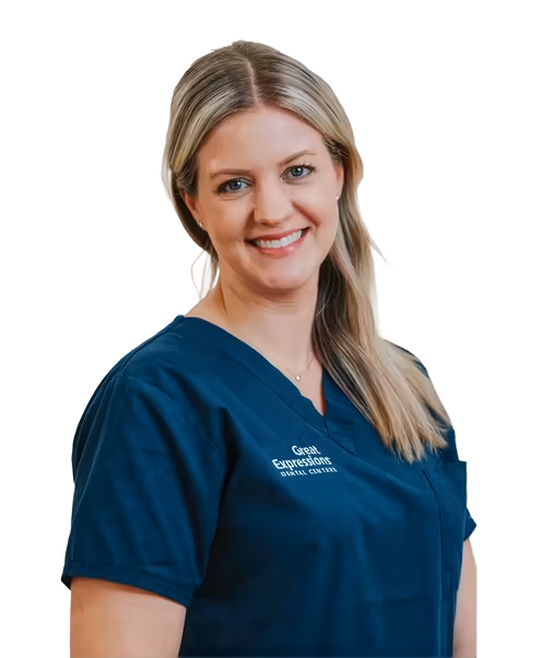 Smiling dentist in blue scrubs.