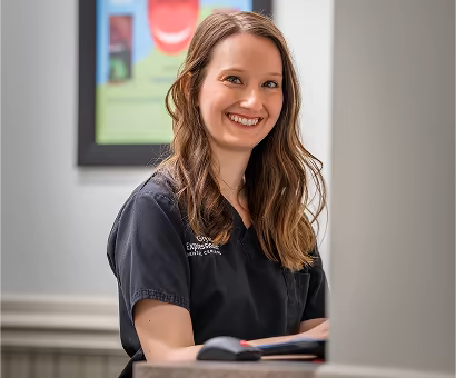 Happy employee working on a computer in a dental office.