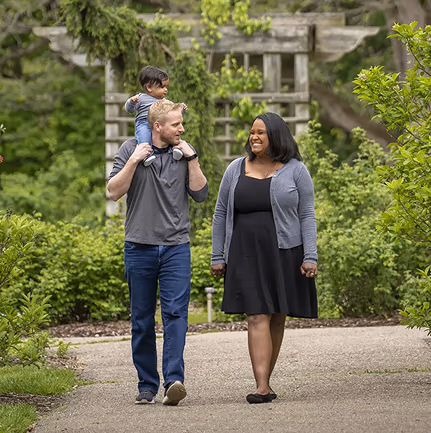 Couple walking in the park with their baby