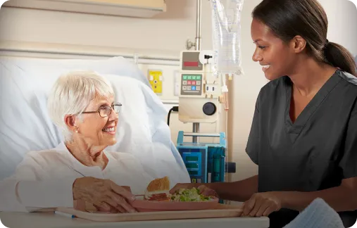 A support services team member assisting an elderly patient.