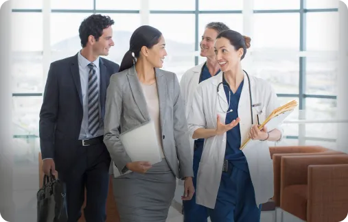 A group of medical and corporate professionals leaving a conference room and talking.