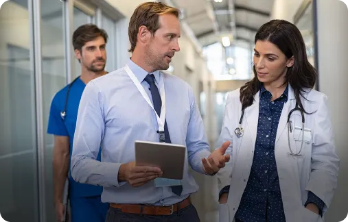 A group of medical professionals reviewing information on a tablet.