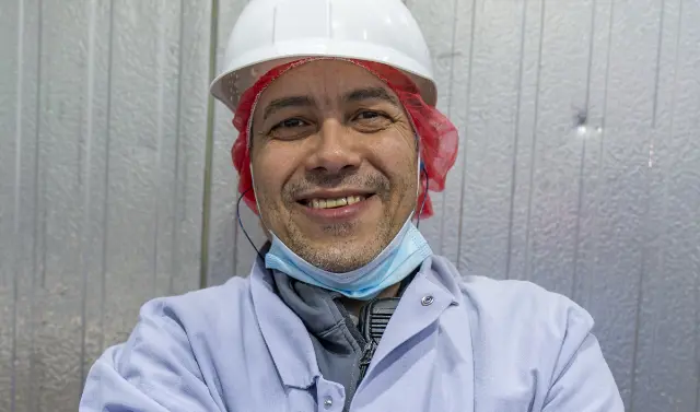  	A Koch Foods employee in a hard hat smiling 