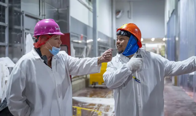  	Two Koch Foods employees smiling while working together