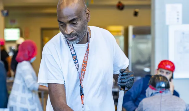  	A Koch Foods employee mopping a cafeteria floor