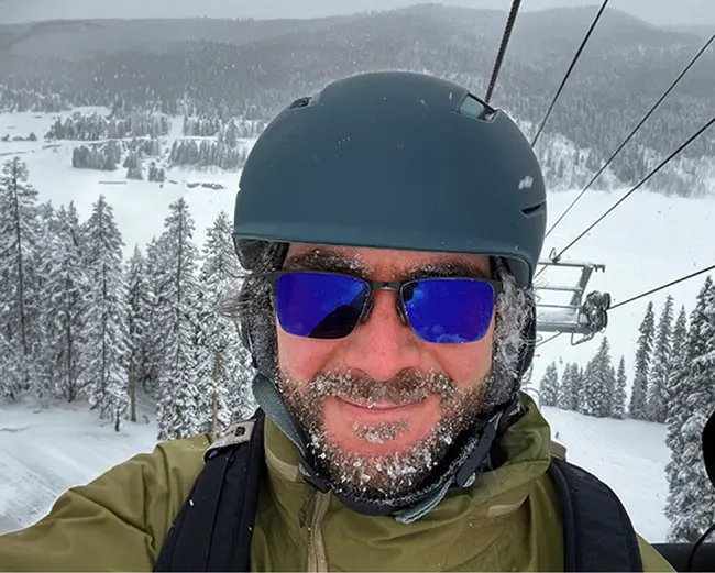 LANL employee, Jasper, smiling from a ski lift.