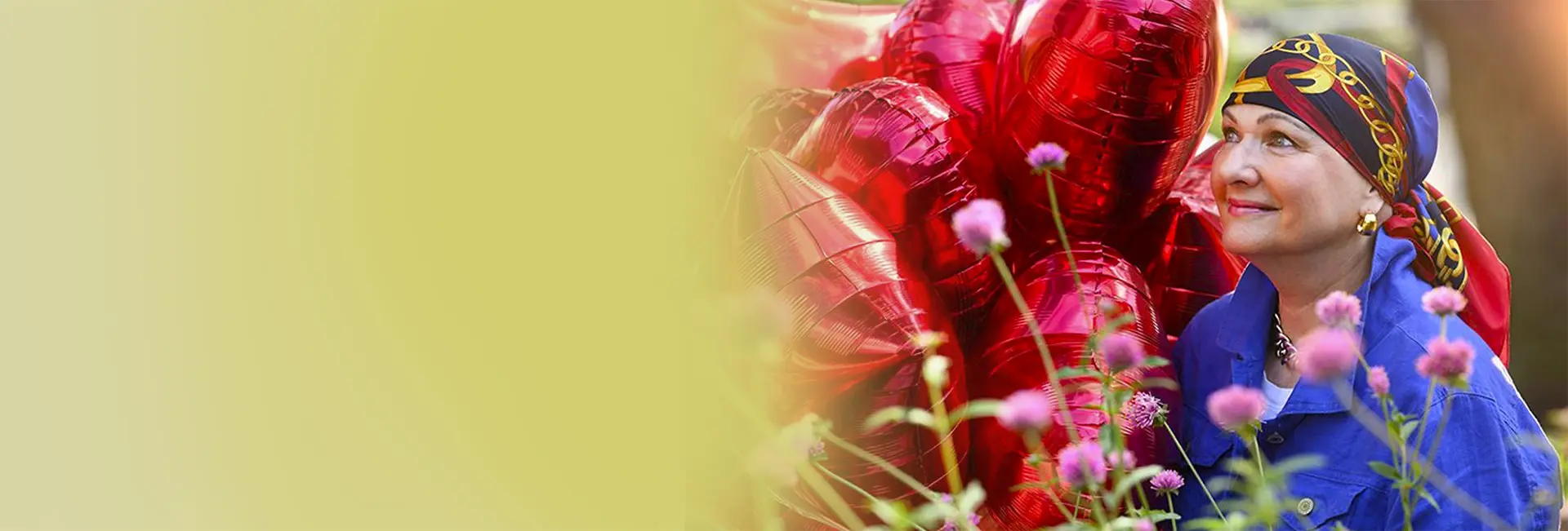 Patient smiling and holding heart-shaped balloons.