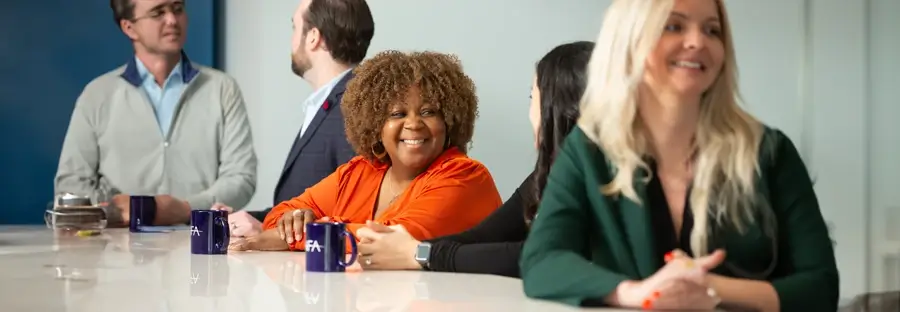 Smiling NFA employees sitting at a table.