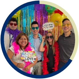 A group of smiling NFA employees posing for a photo at an LGBTQ+ Pride event.