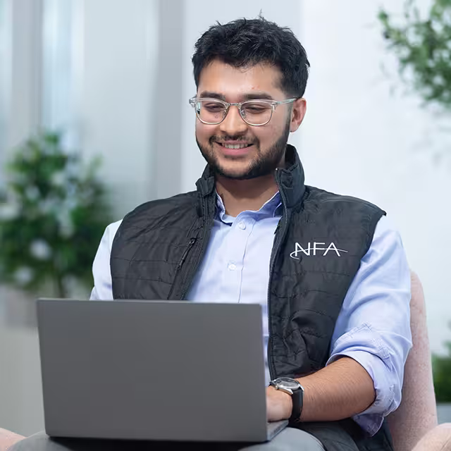 An NFA intern working on a laptop.